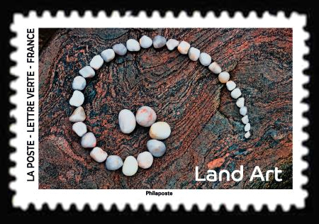  Land Art <br>Spirale de galets blanc sur roche / Adobe stock